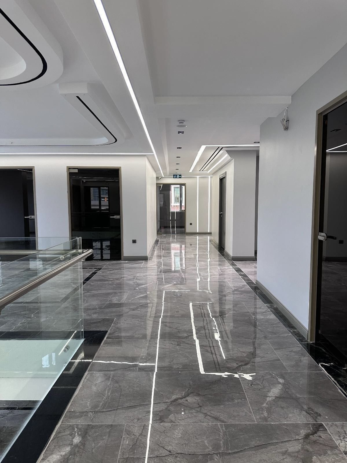Corredor interior da clínica com chão de mármore cinzento