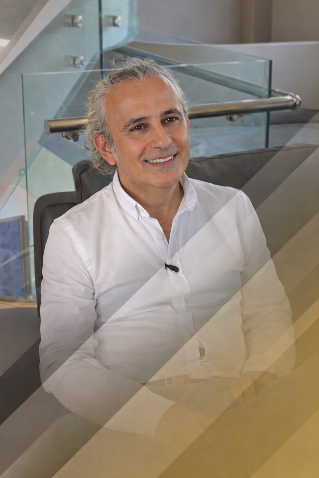 Doutor Merdan Çelik, de camisa branca, a sorrir no interior da clínica em Istambul