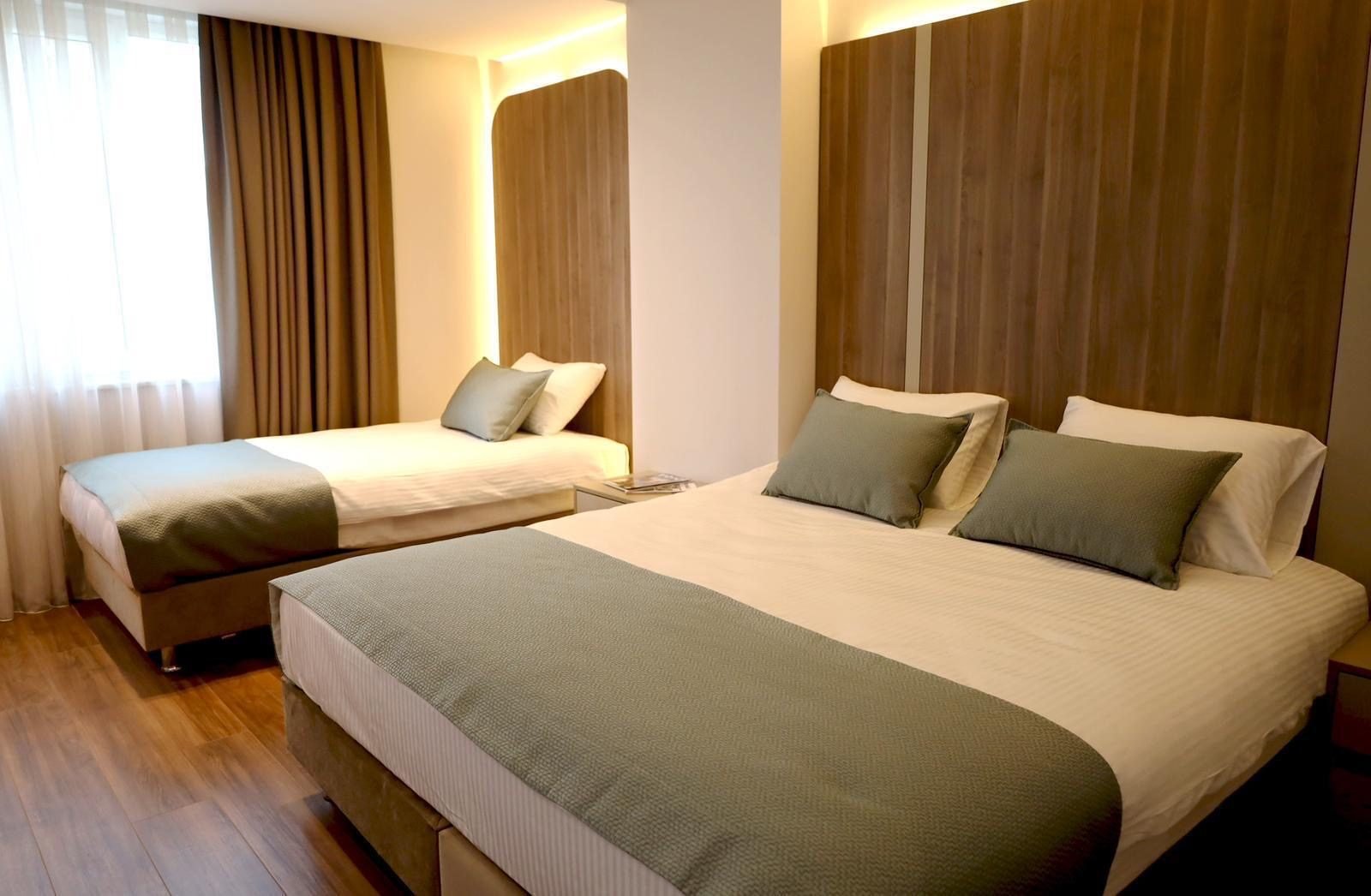 Quarto de hotel com duas camas e cabeceira de madeira